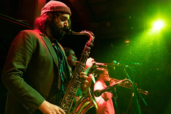 An example of concert photography showing a saxophonist playing energetically on stage during a live concert.